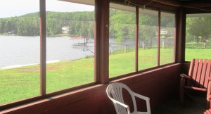 Relax on the screened in porch at the Partridge lake front family cabin